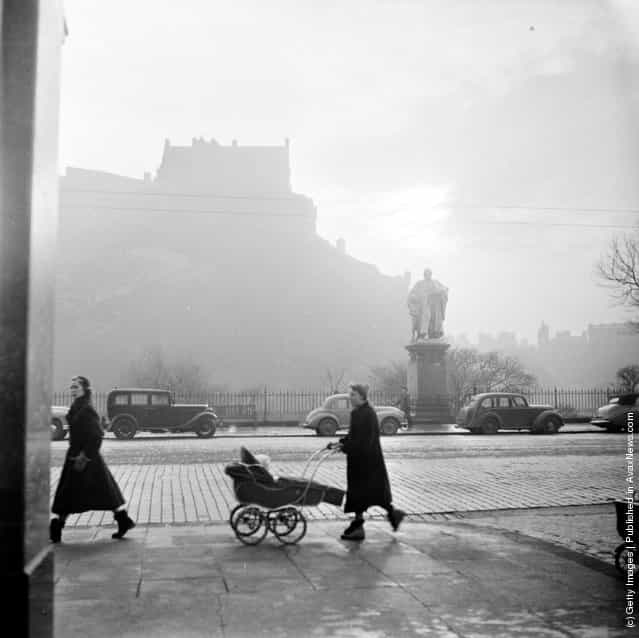 1954: A street scene in Edinburgh with a misty view of the castle in the background