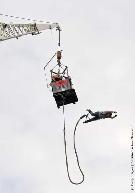 A visiitor bungee jumps during an outdoor festival to celebrate German Unity Day