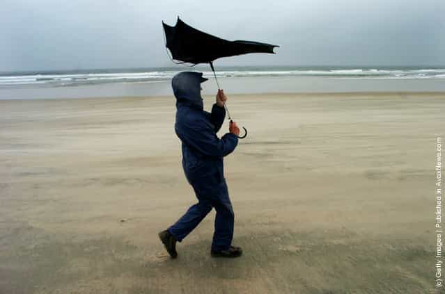 Doris Pennman adjusts her umbrella as she walks along Mission Beach