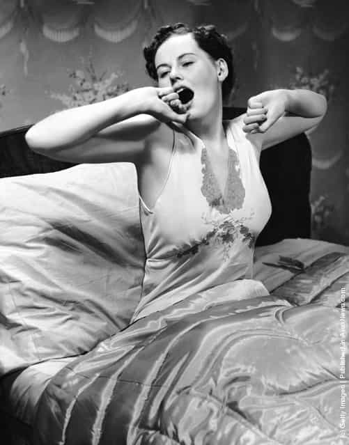 1950s: Woman in bed yawning