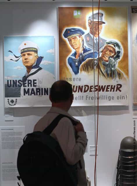 A visitor looks at post-World War II German military recruitment posters