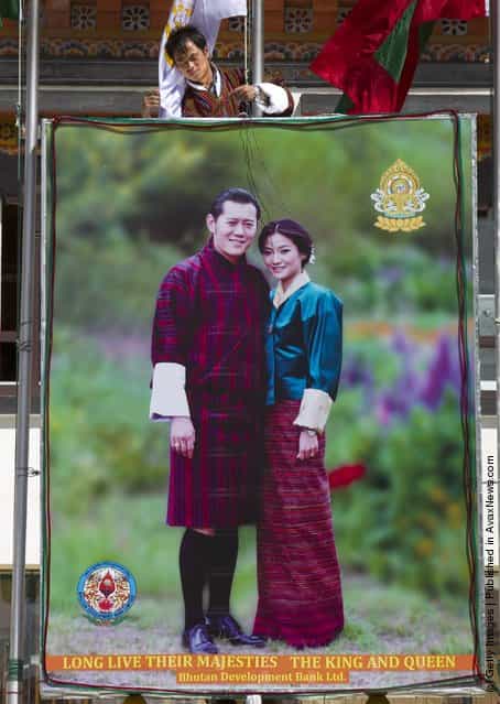 A Bhutanese worker hammers lights onto a portrait of the future King Jigme Khesar Namgyel Wangchuck, and Queen of Bhutan Ashi Jetsun Pema Wangchuck