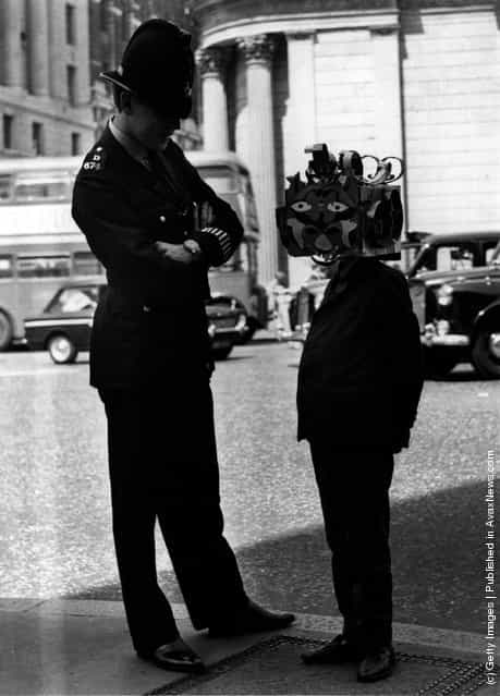A boy wearing an Apollo space mask seen here greeting a policeman, 1969