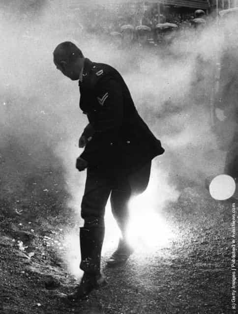 1971: A policeman loses his hat as he runs from a smoke bomb during rioting by anti-apartheid demonstrators at the Melbourne Olympic Park, Australia, during a match between the South African Springboks Rugby team and Victoria