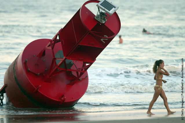 A beachgoer walks past a buoy that washed ashore after Hurricane Isabel made landfall in Virginia Beach, Virginia