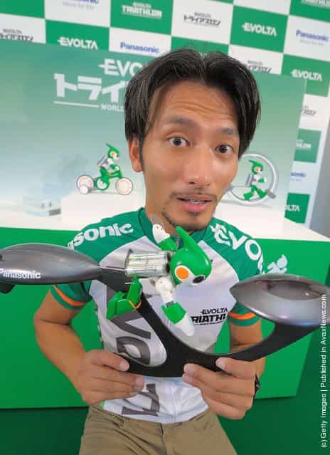 Robot creator Tomotaka Takahashi poses with the swim version of his Evolta robot