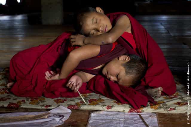 Sangey, 6, and Tenzin, 7, rest after hours of prayer at the Dechen Phodrang monastery in Thimphu, Bhutan