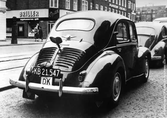1964: The back view of a Renault 4 CV car, parked in the centre of Copenhagen with a large key fitted to the boot giving passers-by the impression of a life-size clockwork car