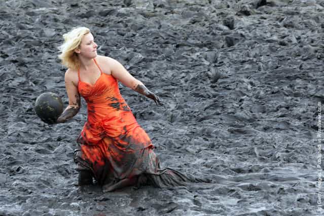 A participant of the fashion show throws a ball during the Mudflat Olympic Games 