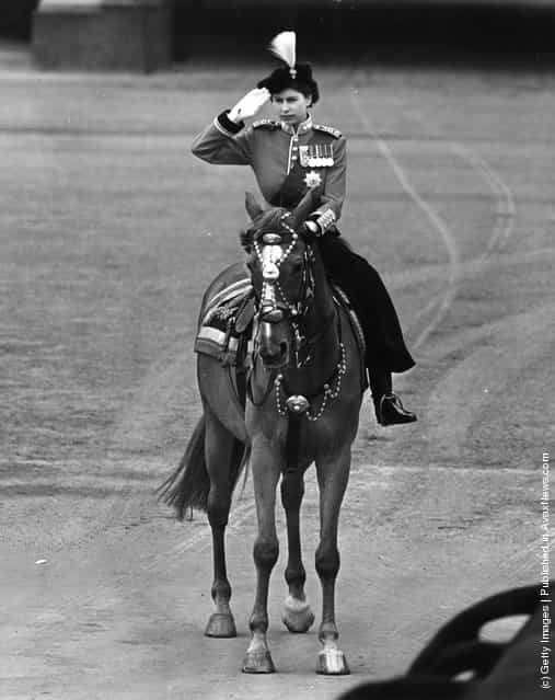 1952: Queen Elizabeth II riding a horse side saddle and saluting during a Trooping of the Colour ceremony at Horse Guards Parade, Central London