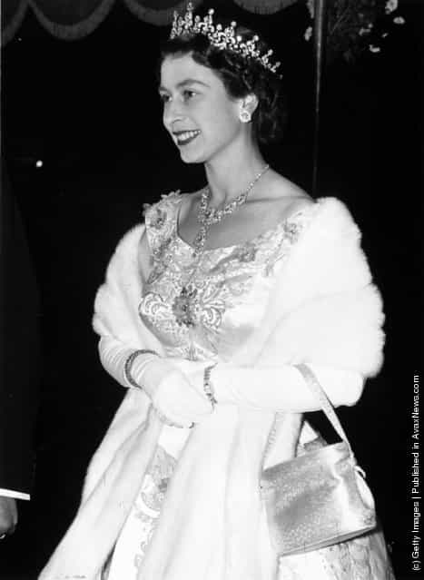 1955: A regally adorned Queen Elizabeth II arriving at the Royal Performance of the film To Catch A Thief at the Odeon Cinema, Leicester Square
