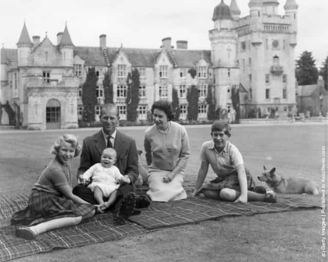 1960: Queen Elizabeth II and Prince Philip, Duke of Edinburgh with their children, Prince Andrew (centre), Princess Anne (left) and Charles, Prince of Wales sitting on a picnic rug outside Balmoral Castle in Scotland