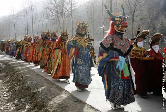 Lamas walk on a road to send evil spirits which have been killed, during the Tiaoqian praying ceremony