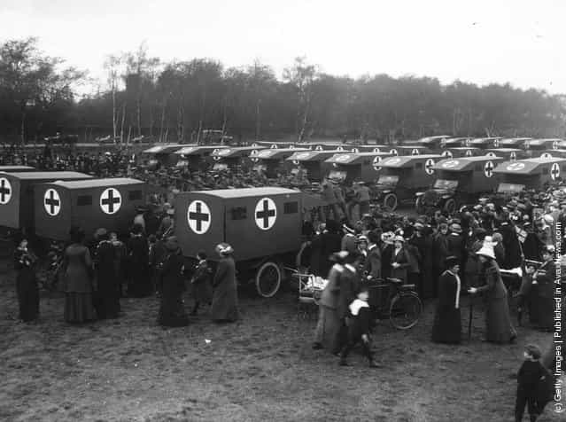 1914: Civilians watch as troops practice amongst a convoy of ambulances at Pilthey