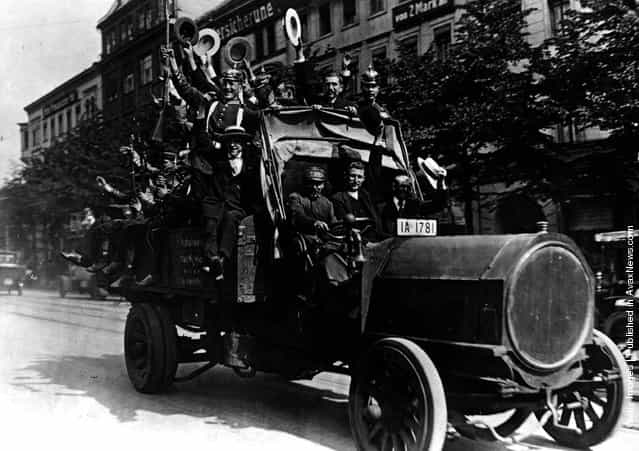 1914: German army Reservists waving and cheering as they rush to join