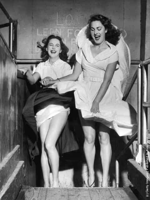 1953: Valerie Carton and Patricia Webb are surprised by a revealing gust of wind in the funhouse