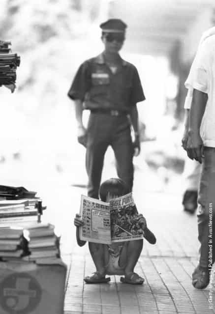 1973: A Vietnamese child reads a comic bought for him by a Vietnamese soldier