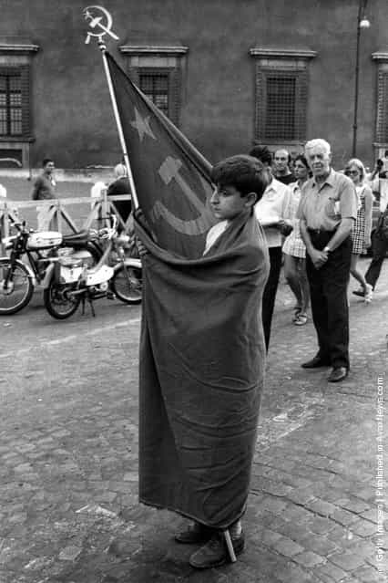 1969: A young Communist wears a Soviet flag at a meeting organised by the Italian Communist Party at the Piazza San Giovanni, in front of the Basilica of St John in Rome, to protest against the current government crisis and political situation