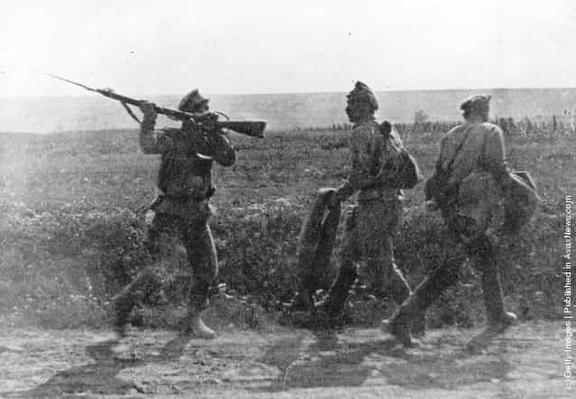 Two army deserters are threatened by a Russian soldier with raised rifle and bayonet, 1914