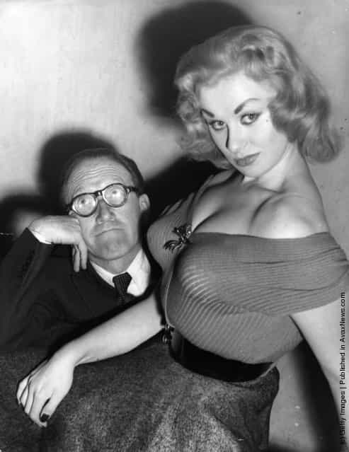 Glamour model and actress Sabrina seated on the knee of Arthur Askey, 1955