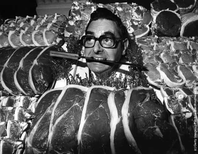 1975: The winner of the Dewhursts Master Butcher of the Year, James Pegg, poses with a knife between his teeth and a selection of meat