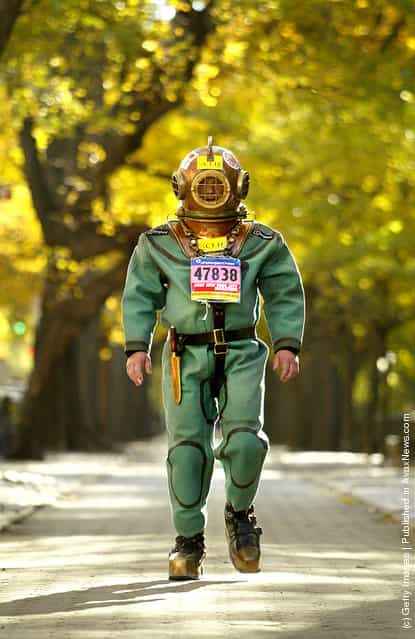 Lloyd Scott wears a 140-pound antique diving suit while walking on Fifth Avenue as he attempts to finish the New York Marathon