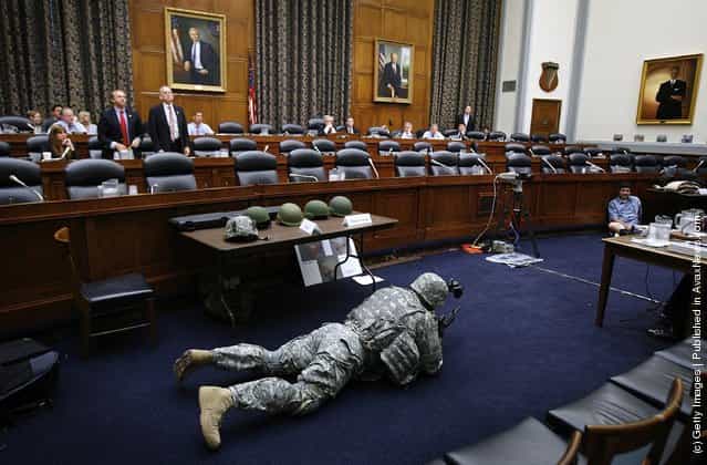Sgt. First Class Jerry Lutz from Fort Belvior, Virginia, demonstrates how early versions of the Army's combat helmets made it difficult to see from a prone shooting postion during a hearing of the US House Armed Services Committee Tactical Air and Land Forces Subcommittee on Capitol Hill