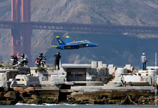 A U.S. Navy Blue Angels F/A-18 Hornet makes a low pass over San Francisco Bay during a practice session for San Francisco Fleet