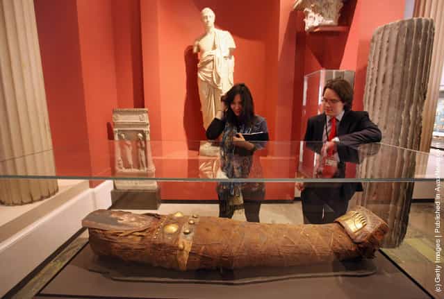 Members of the public view a mummy of a young woman from during the Roman occupation of Egypt in the Ashmolean Museum