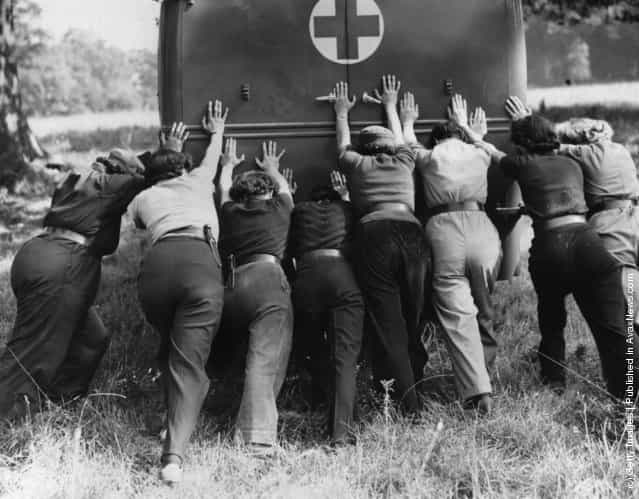 1940: Members of the Womens Mechanised Transport Corps push an ambulance out of some rough ground