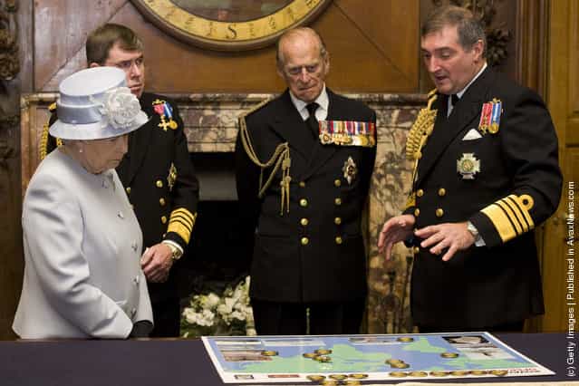 Queen Elizabeth II accompanied by First Sea Lord, Admiral Sir Mark Stanhope (2L) and her husband Prince Philip, Duke of Edinburgh, are shown a map detailing current naval deployments by Admiral Sir Trevor Soar (R) during a visit to the Admiralty Board and Admiralty House