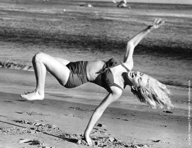 Marilyn Monroe (1926 - 1962) frolicking on the beach near her Hollywood home during a break from filming