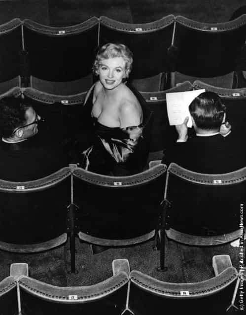 Marilyn Monroe (Norma Jean Mortenson or Norma Jean Baker, 1926 - 1962) takes her seat in the audience for a performance of the play A View From The Bridge, written by her husband Arthur Miller (left). The play is being performed at the Comedy Theatre in London
