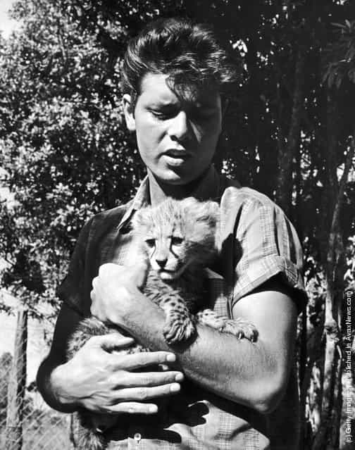 English pop singer Cliff Richard with a cheetah cub during a visit to the game-keepers lodge at the Nairobi Game Park, Kenya, 15th February 1963
