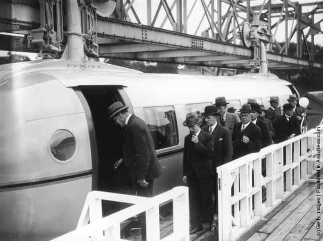 1930: The first load of passengers queuing for the Bennie Railplane in Glasgow; the inventor George Bennie is third in the queue. The streamlined cars are self propelled, driven by air screws in front and behind, and hang from a steel girder