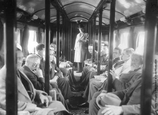 1930: Passengers on the Bennie Railplane in Glasgow; the inventor George Bennie stands at the end of the carriage. The streamlined cars are self propelled, driven by air screws in front and behind, and hang from a steel girder
