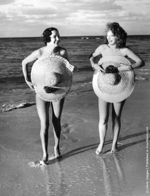 1939: Women covering up on the beach at Nassau with straw hats