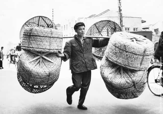 1959: A Guangzhou (Canton) worker transporting wicker baskets made by himself to an agricultural fair. The baskets are mainly used by farmers for transporting live ducks and chickens