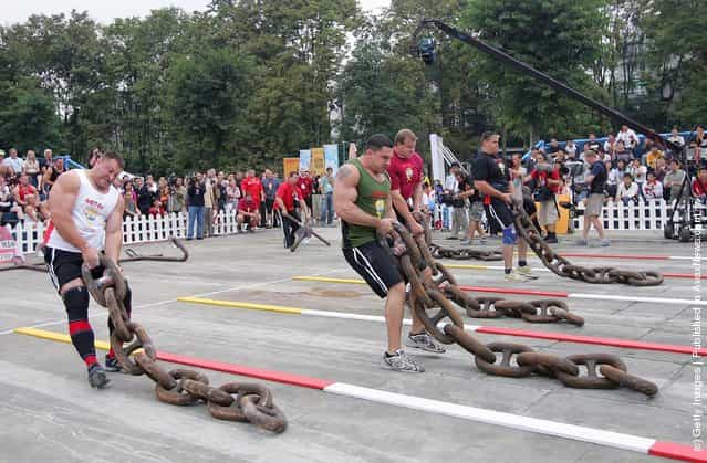 (L-R) Jessen Paulin of Canada, Kevin Nee and Dave Ostlund of USA, Janne Virtanen of Finland drag huge iron chains during a match of the 2005 Worlds Strongest Man Competition at Wuhou Temple