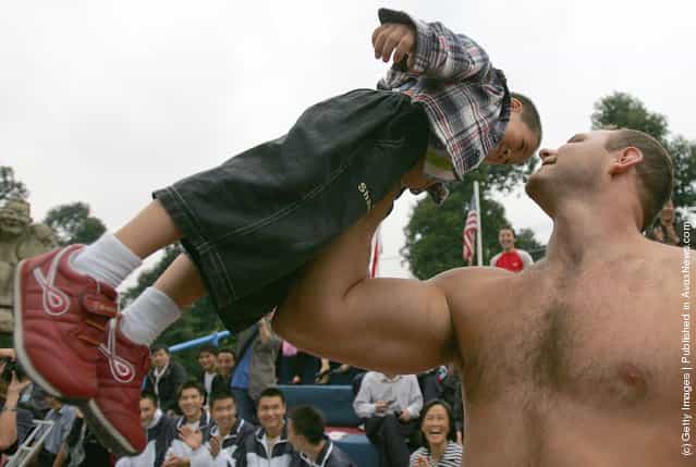 A contestant lifts a Chinese young boy during a match of the 2005 Worlds Strongest Man Competition at Wuhou Temple