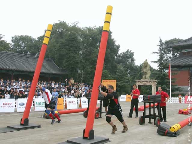 Contestants lift up poles during a match of the 2005 Worlds Strongest Man Competition at Wuhou Temple