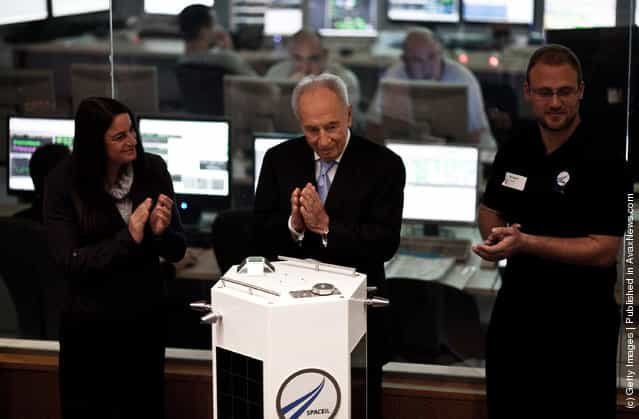 Israeli President Shimon Peres (centre) and Space IL engineers introduce the new prototype nano spaceship during a press conference on December 8, 2011 in Ehud, Israel