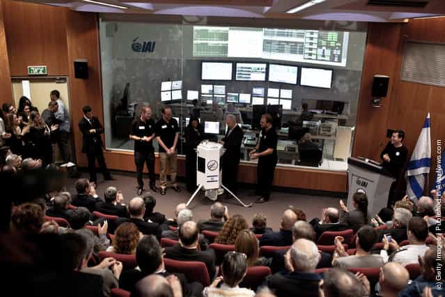 Israeli President Shimon Peres (centre R) and Space IL engineers introduce the new prototype nano spaceship during a press conference on December 8, 2011 in Ehud, Israel