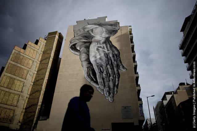 A man walks past graffiti displayed on a building on December 6, 2011 in Athens, Greece