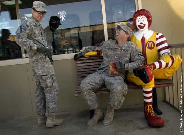 U.S. Army Sergeant James Linville from Brandon, Florida and Justin Herdman from Dover, Arkansas of the 2-82 Field Artillery, 3rd Brigade, 1st Cavalry Division, relax as they order McDonald's meals after arriving in Kuwait from Camp Adder in Iraq