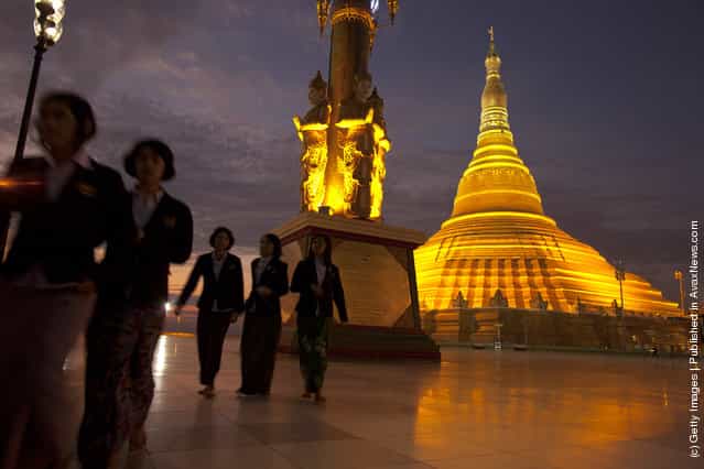 People walk by the Ouparta Thandi pagoda which was built to mirror the famous Shwedagon pagoda