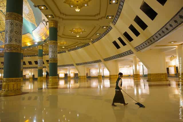 A worker mops the floor inside the hall of the Ouparta Thandi pagoda which was built to mirror the famous Shwedagon pagoda