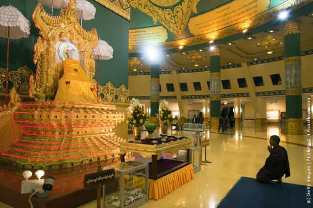A monk prays inside the hall of the Ouparta Thandi pagoda which was built to mirror the famous Shwedagon pagoda