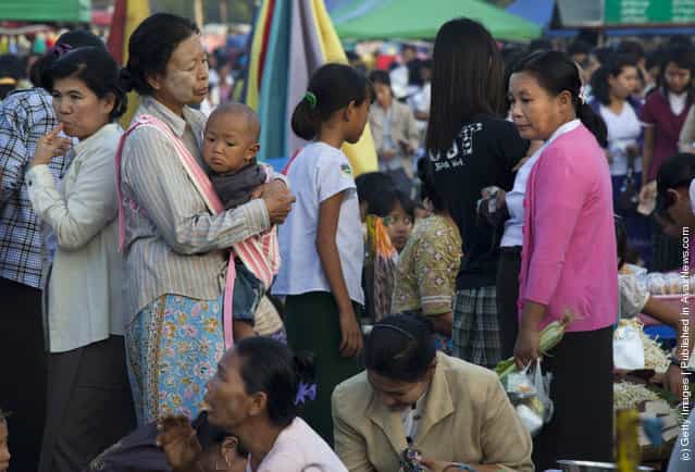 Burmese pack an afternoon market where many government workers buy fresh produce and clothing