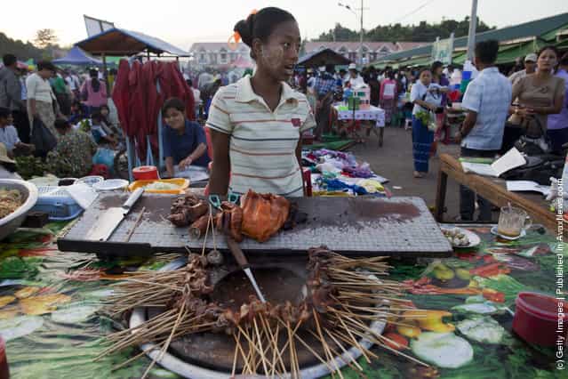 Burmese pack an afternoon market where many government workers buy fresh produce and clothing